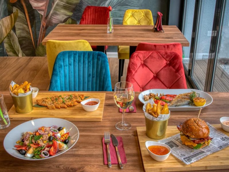 Colorful dining setup in a modern restaurant featuring diverse meals and vivid decor.